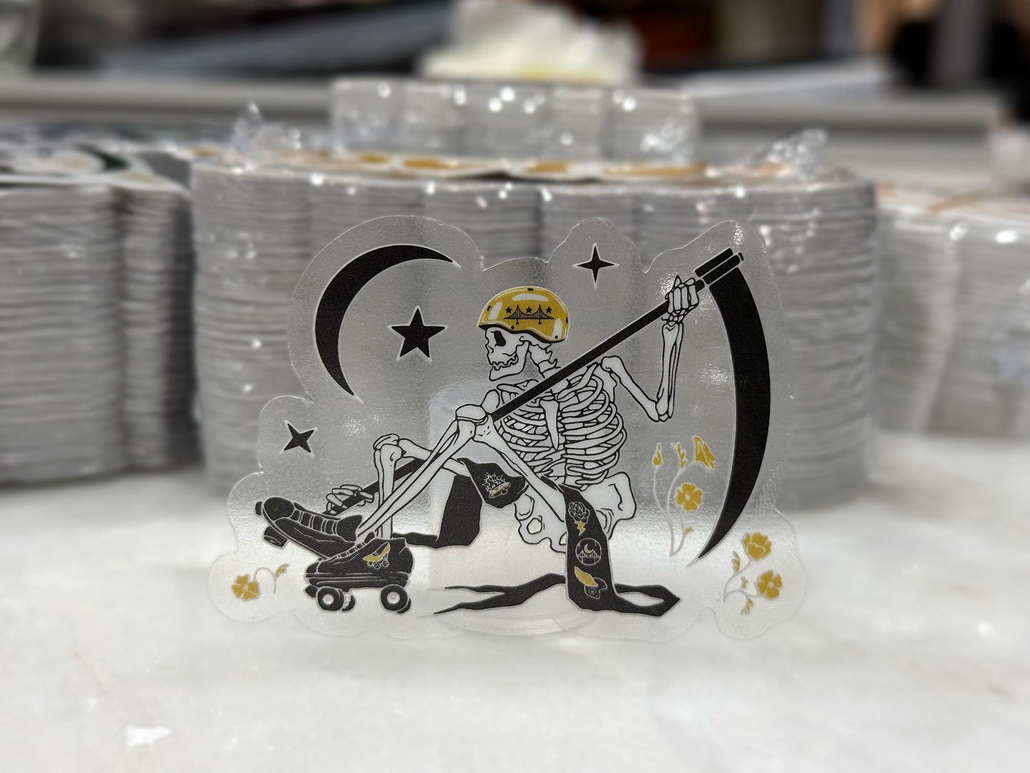Clear sticker featuring an opaque white skeleton in front of stacks of stickers