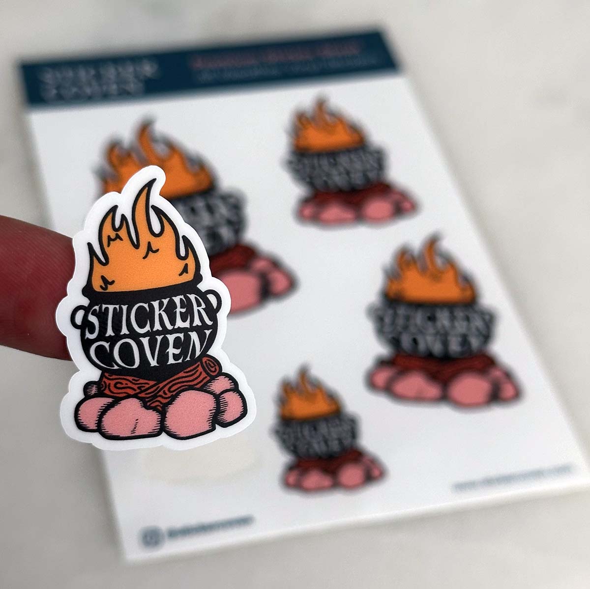 A sheet of custom vinyl stickers with a design that includes flames and the text 'STICKER COVEN'
